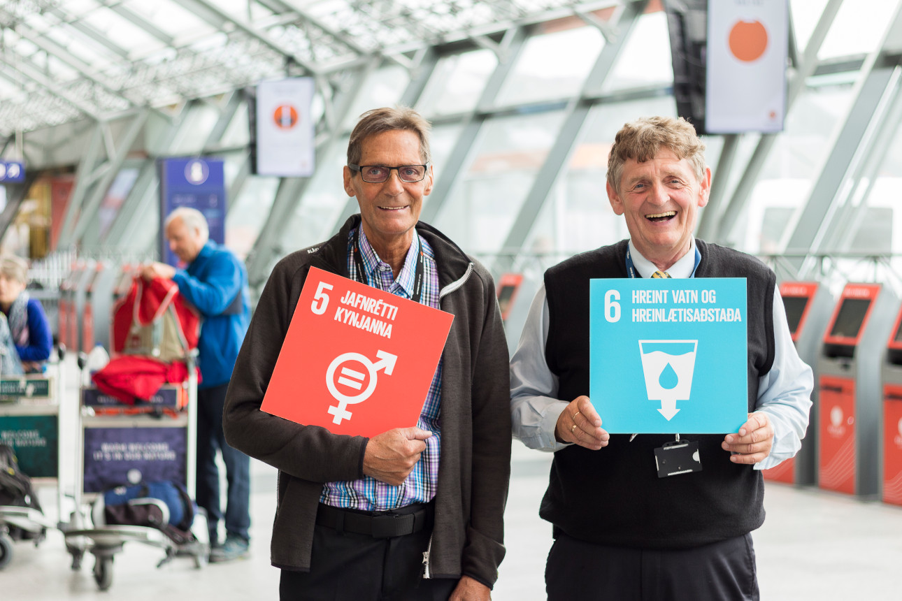 Two employees showing Sustainable development goals in the departure area